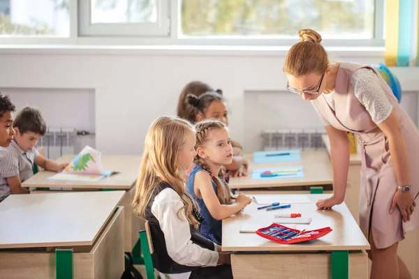 Profesor ayudando a los niños con su tarea en el aula de la escuela — Foto de Stock