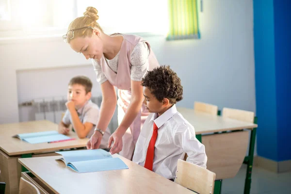 Profesor ayudando a los niños con su tarea en el aula de la escuela — Foto de Stock