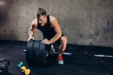 Sportif yakışıklı, neşeli adam antrenman için disk hazırlıyor.