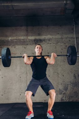 Halterli genç kendine güvenen vücut geliştirici.