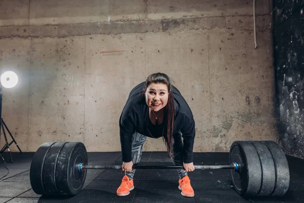 Mujer regordeta no puede levantar la barra en el gimnasio — Foto de Stock