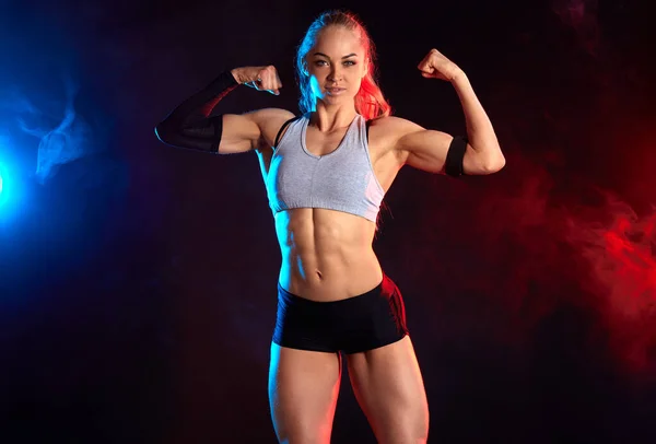 Strong cheerful female bodybuilder with ponytail showing her perfect, ideal body — Stock Photo, Image