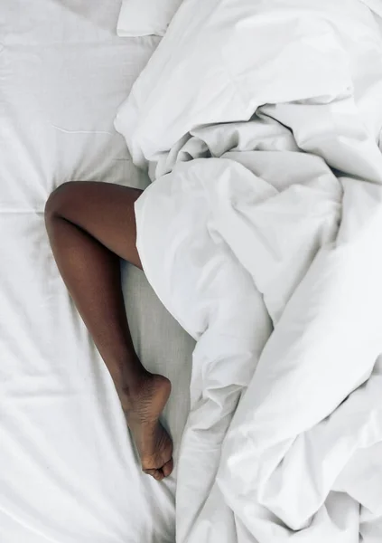 Nahaufnahme von oben. Nacktes Bein auf dem Bett — Stockfoto