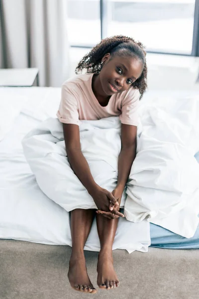 Gut aussehendes Mädchen sitzt morgens auf der Bettkante — Stockfoto