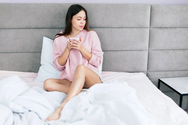 Awesome beautiful girl drinking coffee on bed in the morning in apartment — Stock Photo, Image