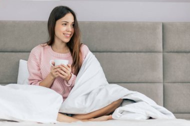 Gülümseyen kız pencereye bakıyor.