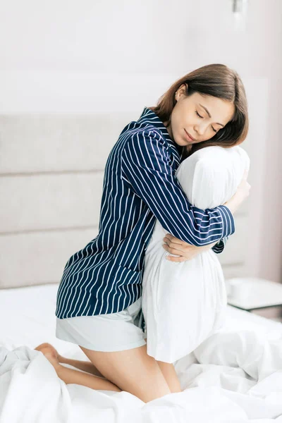 Sexy ehrfürchtige Frau umarmt das Kissen — Stockfoto