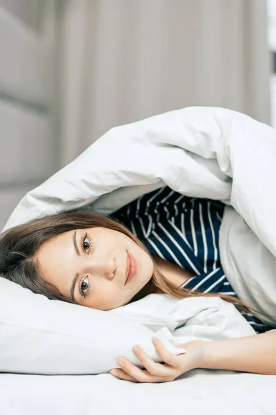 Smiling good looking housewife spending weekends in bed — Stock Photo, Image