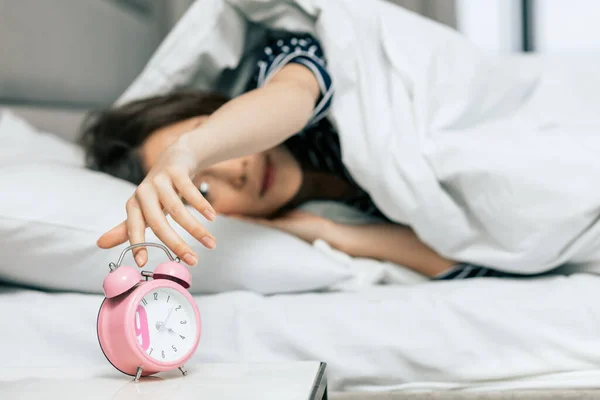 Good looking girl turning off the clock — Stock Photo, Image