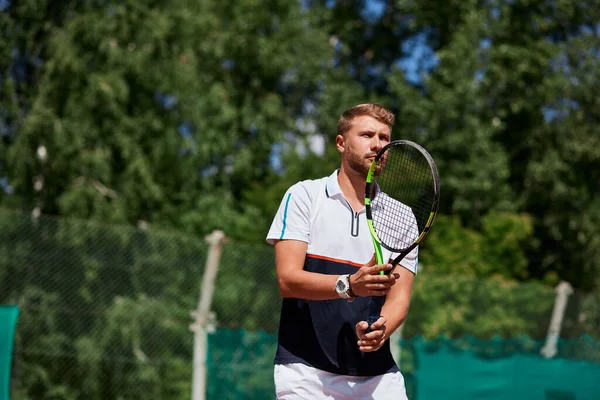 Joven en ropa deportiva está jugando al tenis en la pista de al aire libre. —  Fotos de Stock