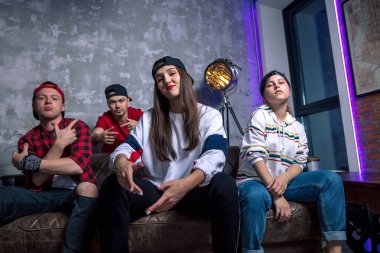 Yetenekli rap şarkıcıları kanepede oturuyorlar.
