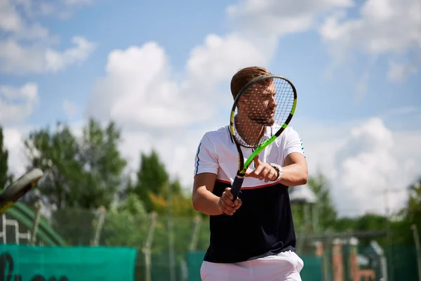 Młody mężczyzna w sportowym stroju gra w tenisa na boisku.. — Zdjęcie stockowe