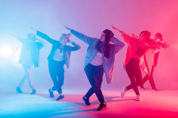 Grupo de diversos jóvenes bailarines de hip-hop en estudio con efectos especiales de iluminación — Foto de Stock