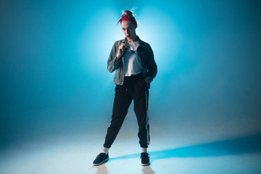 Modaya uygun genç bir kadın kulüpte tek başına dans ediyor, neon ışıklı, dumanlı..