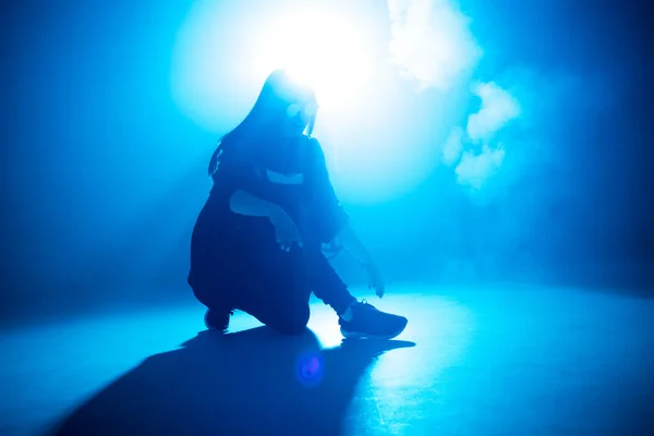Junge Hip-Hop-Tänzerin tritt in blauem Neonlicht solo auf der Bühne auf — Stockfoto