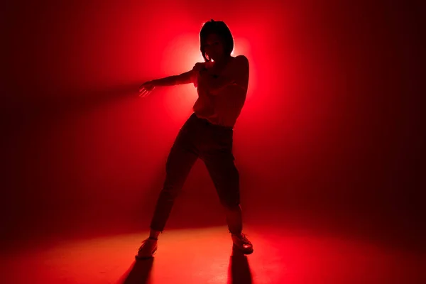 Dançarina elegante em pé na dança posar no fundo do estúdio vermelho — Fotografia de Stock