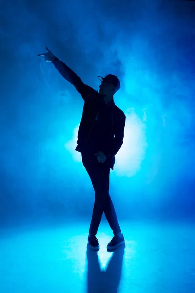 Bailarín masculino profesional bailando en club nocturno con humo y luces de neón azul —  Fotos de Stock