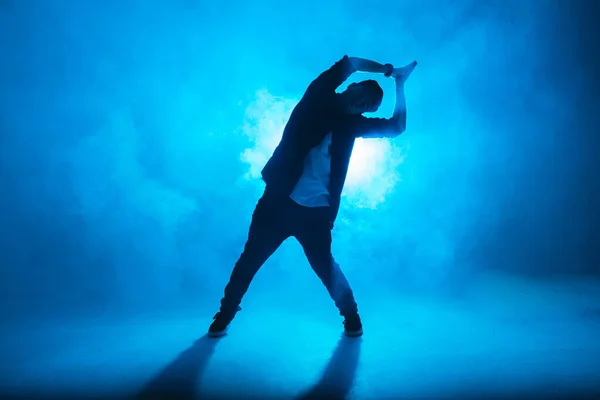 Uma silhueta escura de um cantor no palco, dançando sozinho durante a performance . — Fotografia de Stock