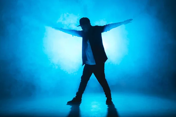 Man break danser voert op blauw neon podium zijn expressieve dans, licht flare — Stockfoto