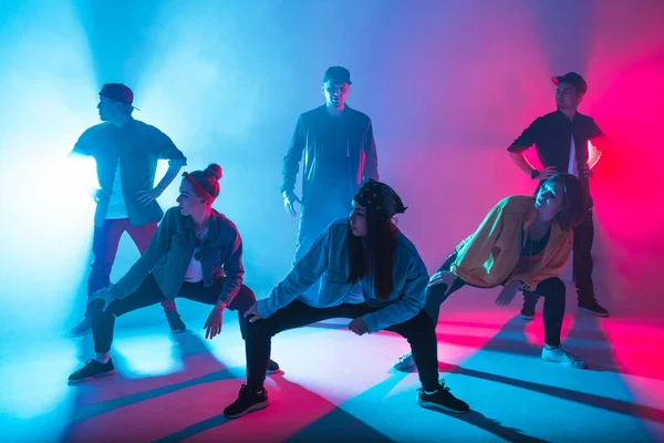 Grupo de bailarines masculinos y femeninos en colorida luz de neón divirtiéndose bailando. — Foto de Stock