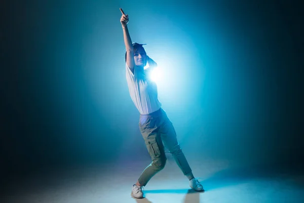 Stylish woman dancing solo on hip hop party. Sunglasses, smoke, neon lights.