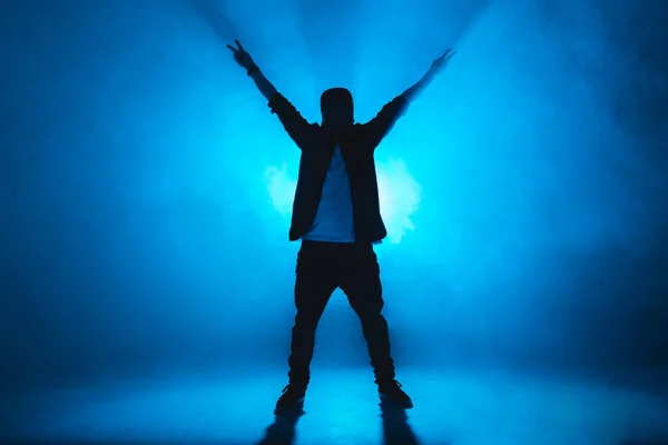 Sportieve moderne stijl hiphop danser toont zijn dans op blauwe studio achtergrond. — Stockfoto
