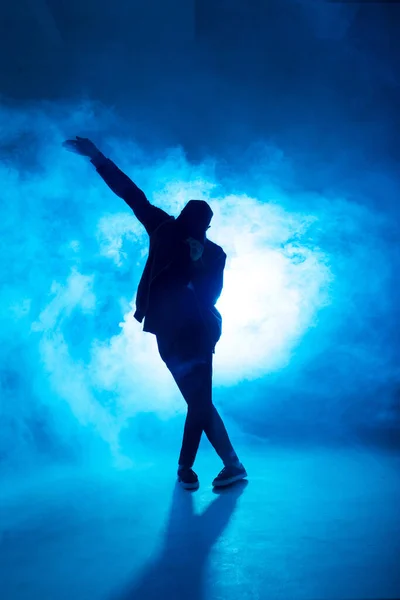 Bailarín de descanso masculino realiza en el escenario de neón azul su danza expresiva, destello de luz —  Fotos de Stock