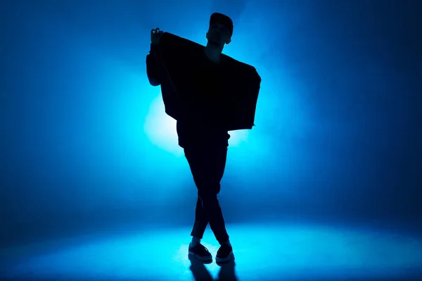 Silhouette of male dancer isolated on blue neon background with flare in middle — Stock Photo, Image