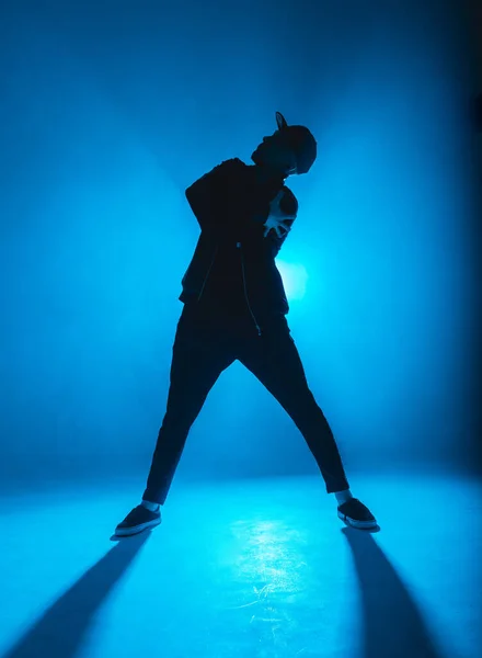 Männersilhouette tanzt in Club mit blauem Neonlicht und Rauch. — Stockfoto