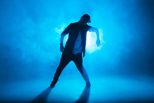 Jovem dançarino dançando funky hip hop no estúdio isolado neon blue background — Fotografia de Stock