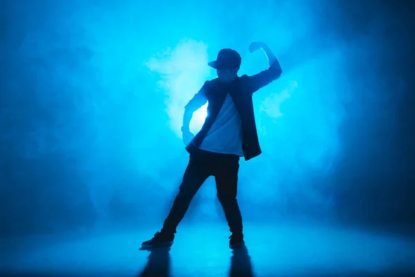 Sportieve moderne stijl hiphop danser toont zijn dans op blauwe studio achtergrond. — Stockfoto