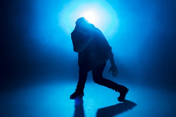 Jovem dançarino dançando funky hip hop no estúdio isolado neon blue background — Fotografia de Stock