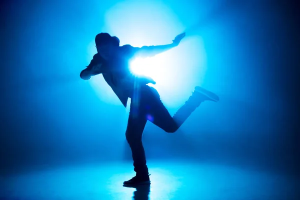 Una silueta oscura de un cantante en el escenario, bailando solo durante la actuación. — Foto de Stock