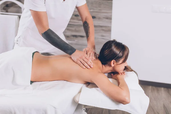 Homem massageando clientes dolorido de volta — Fotografia de Stock