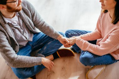Mutfaktaki çift bir fincan kahve ve akıllı telefonla vakit geçiriyor.