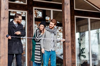 Evin yanında duran emlakçı ve müşteriler.