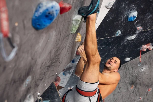 Escalador profesional masculino en el entrenamiento interior en el centro de bouldering. —  Fotos de Stock