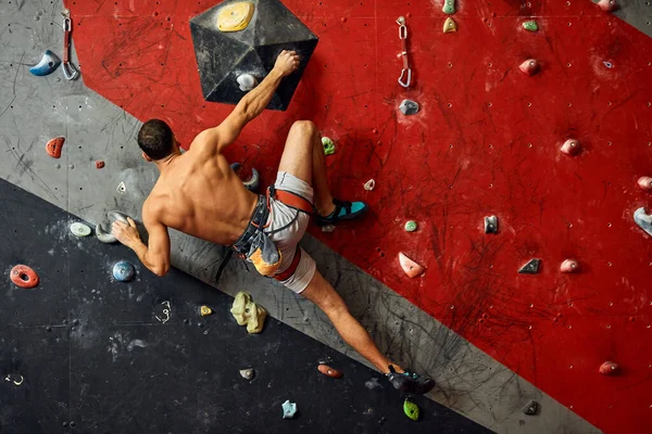 Prise de vue panoramique d'un jeune homme musclé s'entraînant dans une salle de gym intérieure. — Photo