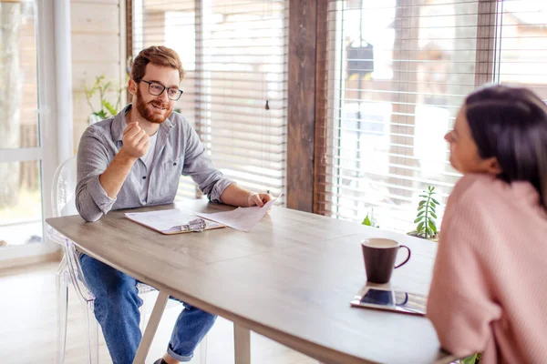 Un homme et une femme sont assis à une table en face de l'autre. — Photo