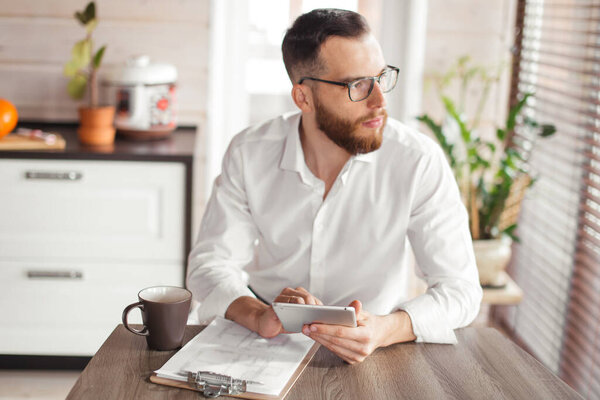 Serious applicant sitting in boardroom, preparing for interview with employer.
