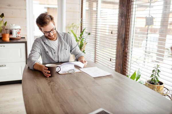 Serious applicant sitting in boardroom, preparing for interview with employer.