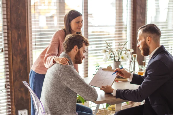 Familiepaar in gesprek met agent in functie, kopen, huren appartement of huis. — Stockfoto