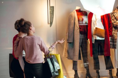 İki kadın kadınların önünde dikiz aynasından butik koleksiyonu yapıyor..