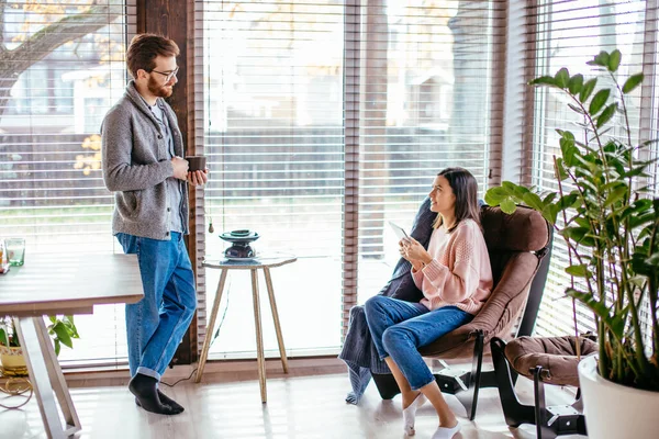 Pareja joven pasando la mañana en un nuevo hogar, discutiendo sus planes para el futuro — Foto de Stock