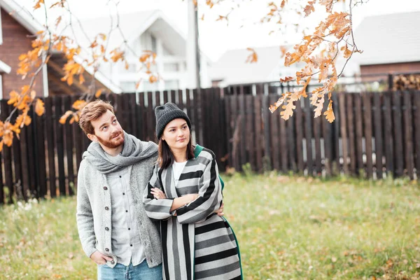 Щаслива молода пара сидить на вулиці, перед своїм новим будинком в осінній день — стокове фото
