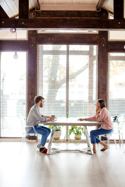 Casal compartilhando ideias, sentado em frente perto de uma grande janela . — Fotografia de Stock