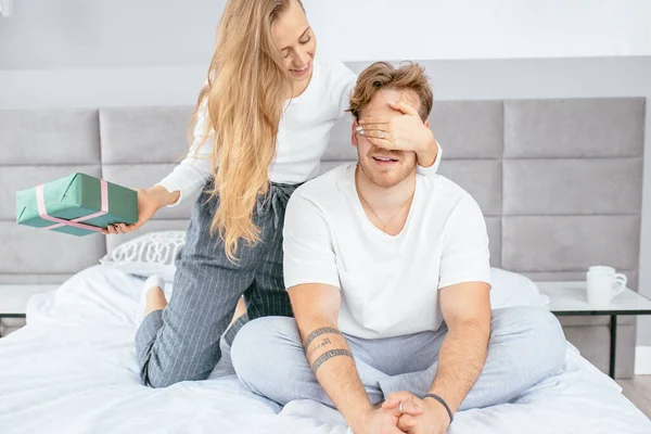 Donna sta per fare un regalo a sorpresa per l'uomo in camera da letto — Foto Stock