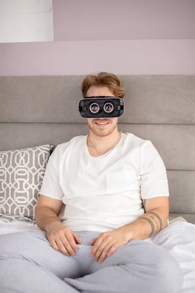 Homem bonito vestindo óculos de realidade virtual em casa — Fotografia de Stock