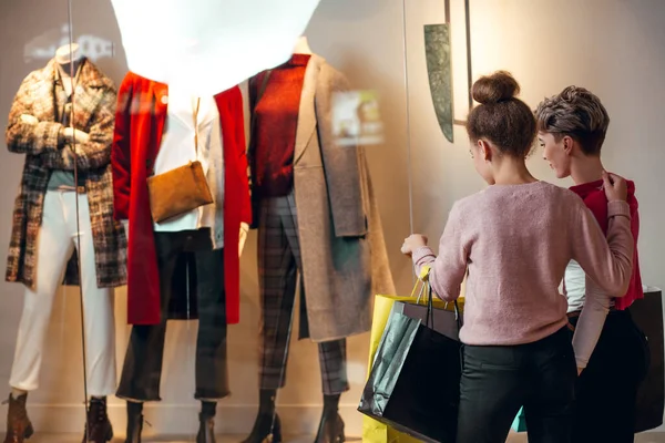 İki kadın kadınların önünde dikiz aynasından butik koleksiyonu yapıyor..