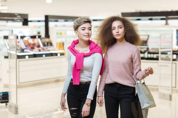 Twee beste vrienden collega meisjes poseren bij moderne winkelcentrum achtergrond — Stockfoto